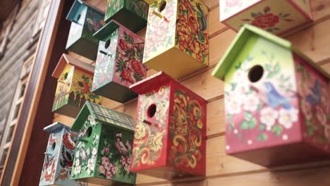 colorful painted birdhouses on a wooden wall