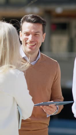 business professionals engaging in an outdoor discussion with a tablet