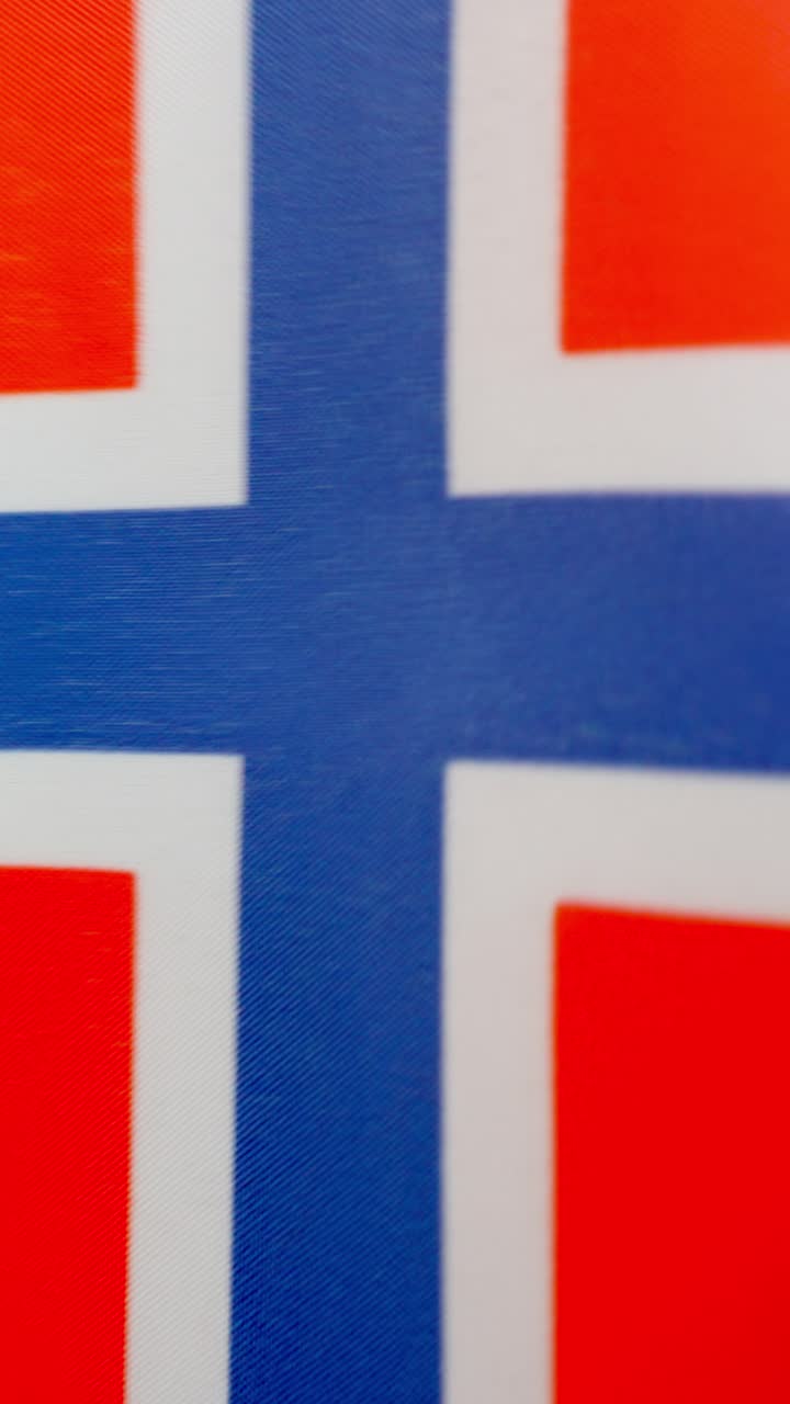 Vertical video of norwegian national flag waving by the wind