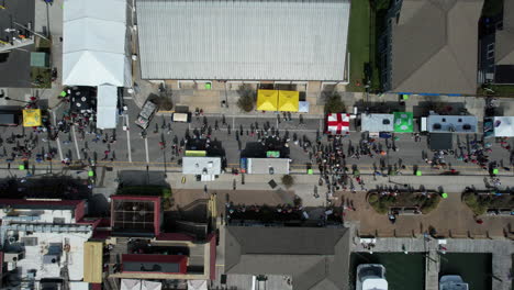 downward angle drone shot of people walking an outdoor festival