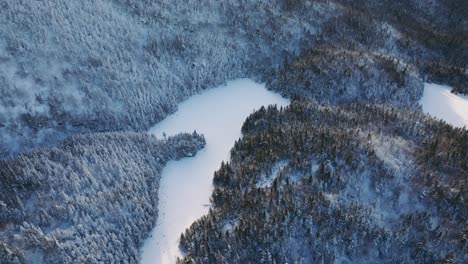 vista panorámica de las montañas del bosque con río congelado durante el invierno en el este de quebec, canadá