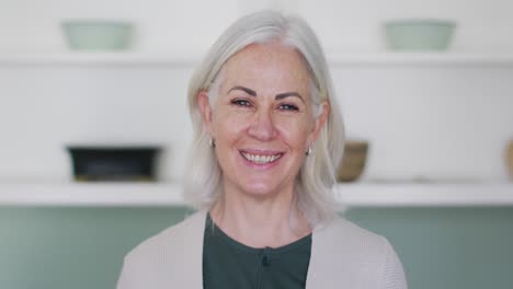 Portrait-of-happy-senior-caucasian-woman-at-home-smiling-to-camera