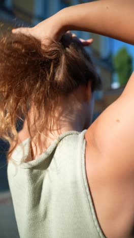 woman adjusting her curly hair