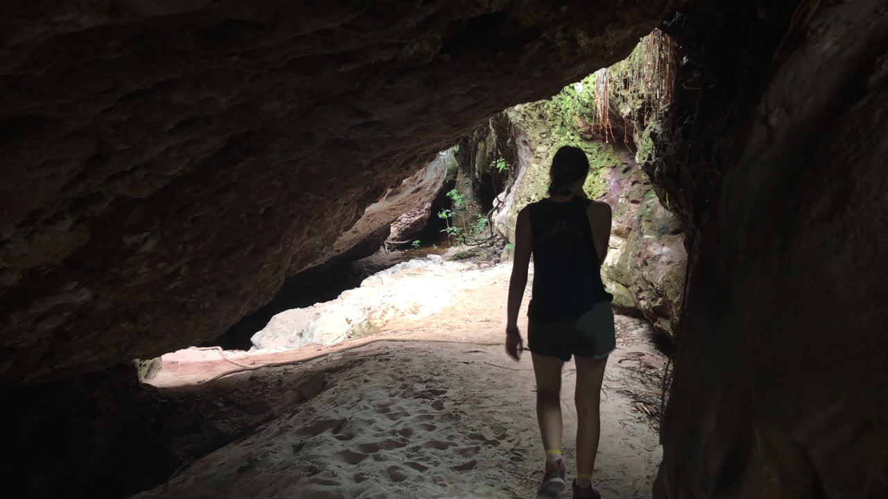 A white blond lady leaves a cave in Chapada Diamantina, Brazil, slowmotion