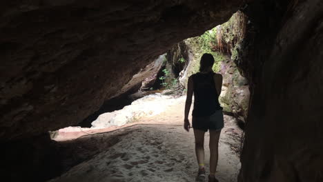 a white blond lady leaves a cave in chapada diamantina, brazil, slowmotion