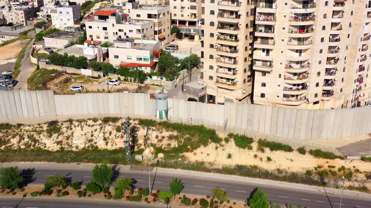 Aerial View of a Security Wall and Watchtower Dividing an Urban Landscape