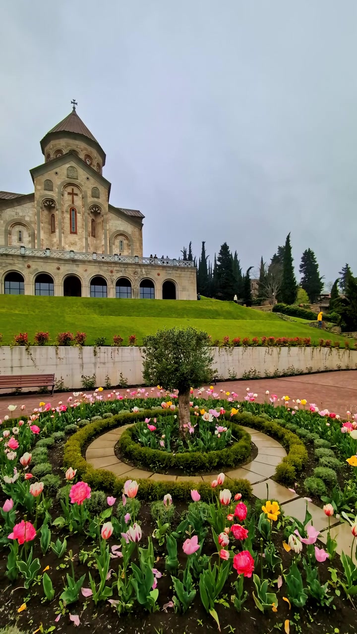Canteiro de tulipas coloridas no jardim da Catedral de Sameba em Batumi, Geórgia, em um dia nublado