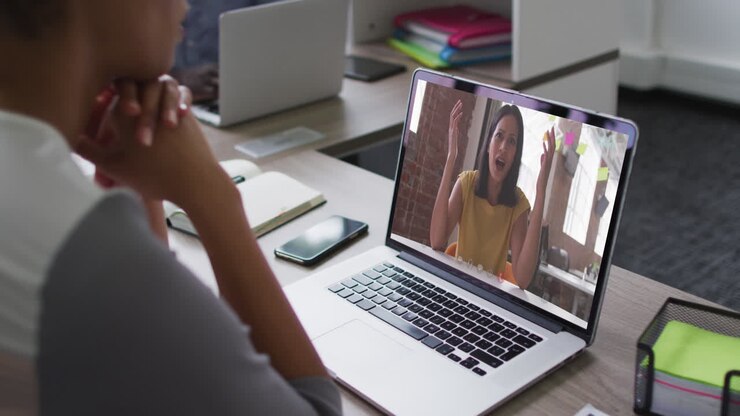 Mid section of african american woman having a video call on laptop with female colleague at office