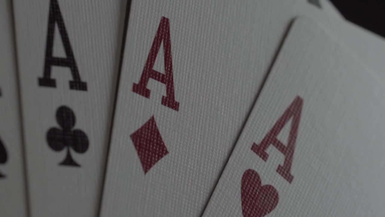 Macro close up of four aces playing cards fanned out, showcasing winning poker hand with sharp card symbols and selective focus for casino and gambling concepts