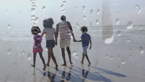 animation of happy african american family walking at beach holding hands over droplets