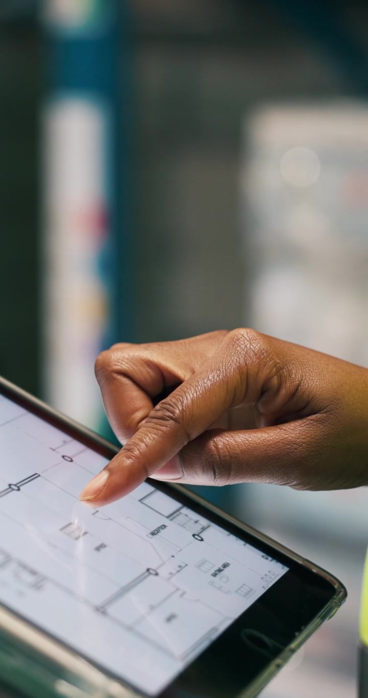 Architect Reviewing Building Floor Plans on Digital Tablet