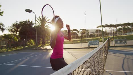 video de una feliz jugadora de tenis afroamericana sosteniendo una raqueta y golpeando la pelota