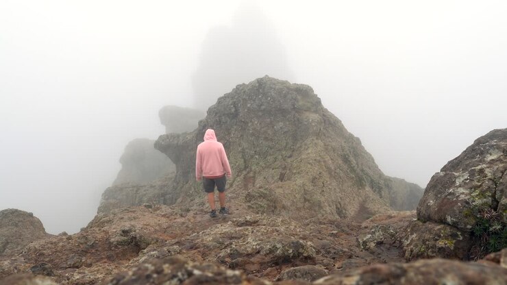 Persona su una montagna nella nebbia