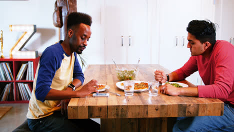 Gay couple interacting with each other while having meal