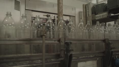 conveyor belt showing clear plastic bottles moving along assembly line in manufacturing plant