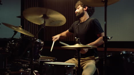 rock musician hitting drum cymbals in concert hall. drummer playing on drum kit.