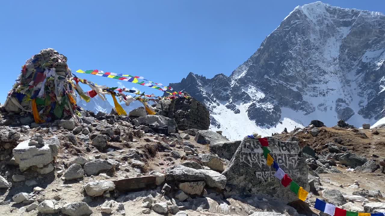 banderas de oración ondeando en el viento en la caminata hacia el campamento base del everest en las montañas del himalaya de nepal