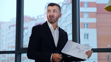 boss discussing graph with his employees. businessman is asked a question, he takes a pause, sips coffee and proceeds.