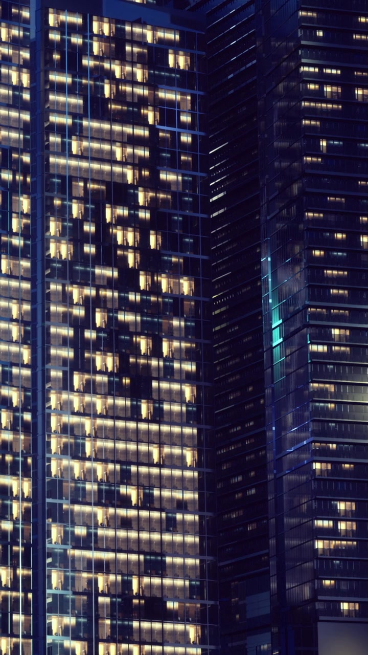 City buildings glow at night with many lights on in a busy area
