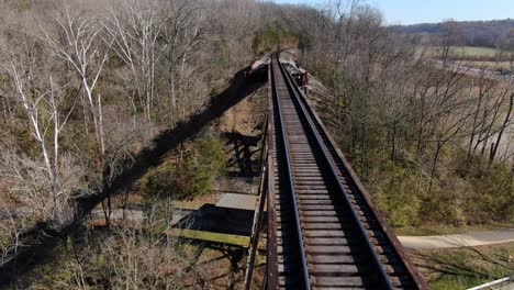 aerial shot pushing forward along the tracks of the pope lick railroad trestle in louisville kentucky on a sunny winter day