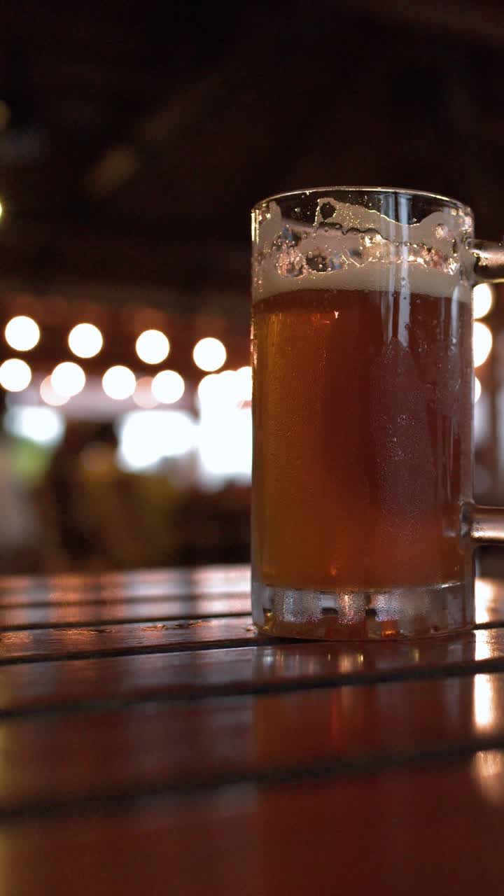 Birra lager fredda in boccali di vetro poggia su un tavolo di legno con un'illuminazione bokeh calda.