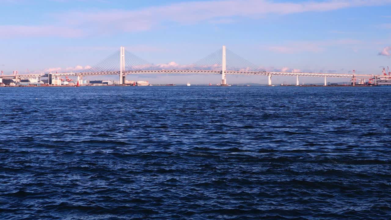 Vehicles crossing the Yokohama Bay using the bridge in the distance.