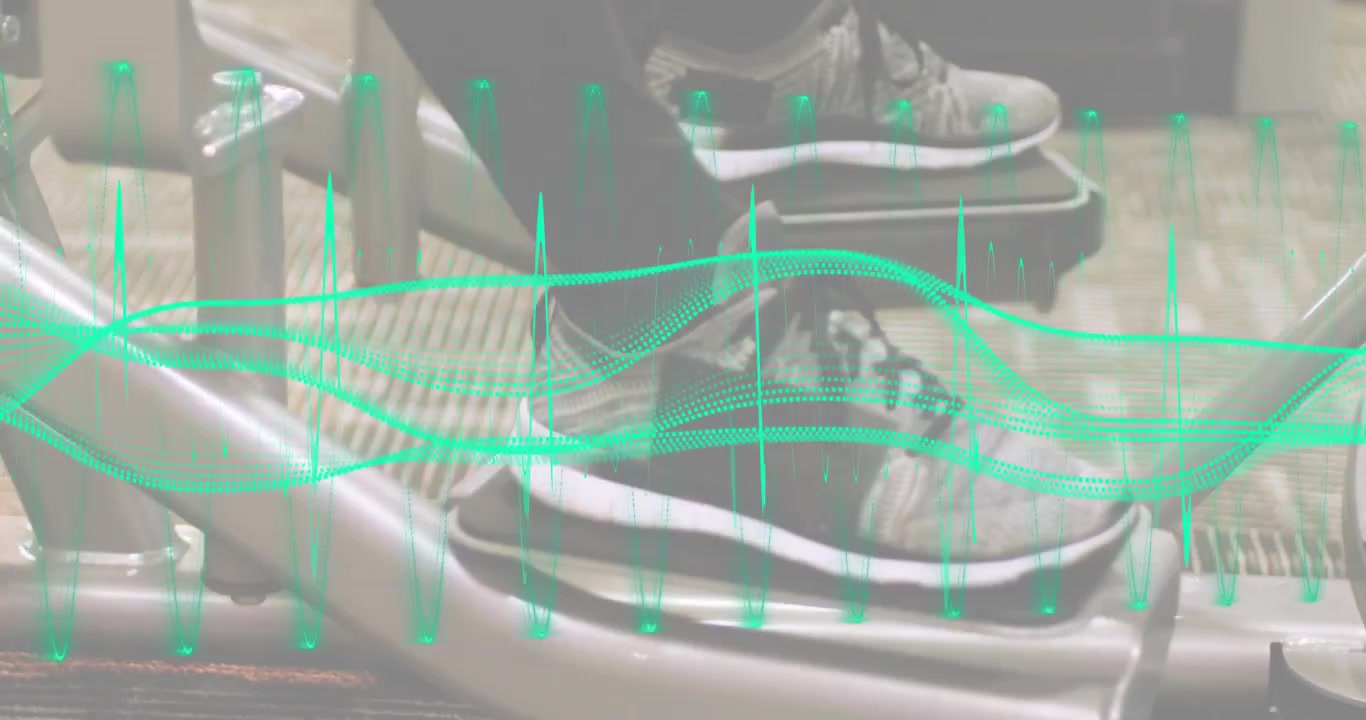 Woman using extension machine and extending legs while pulsing green waveform driving quad workout