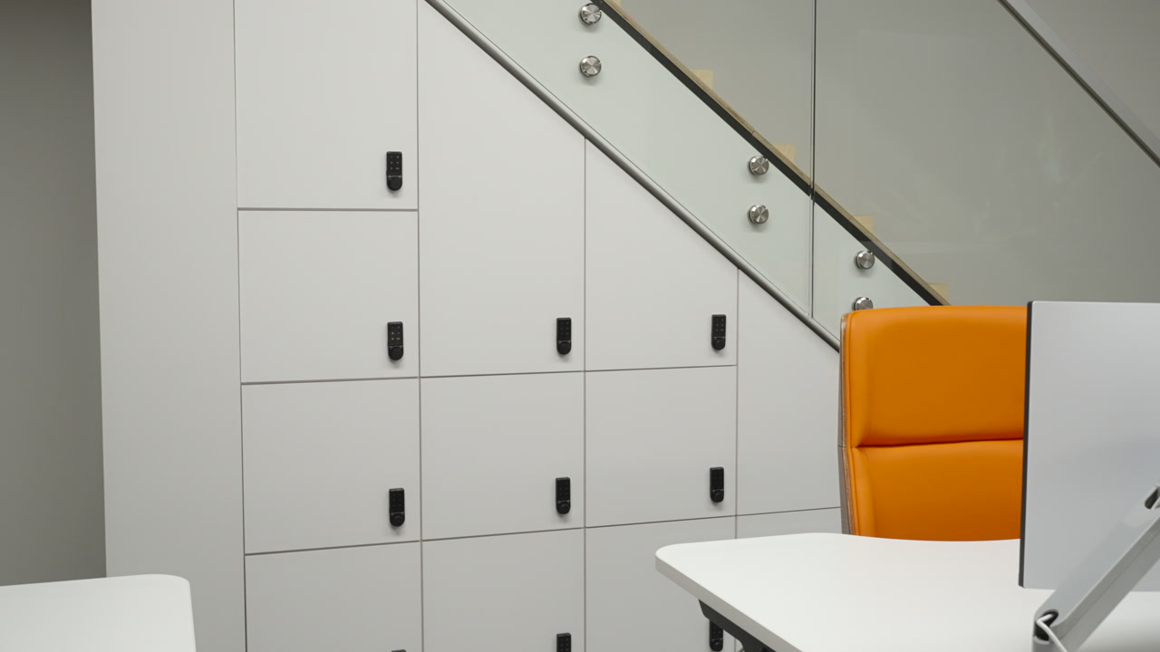 Modular Lockers Built Under Staircase With Orange Chair, Triangular Storage Layout, Keyed Compartments, Sleek. Creative