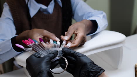 woman choosing nail polish color at nail salon