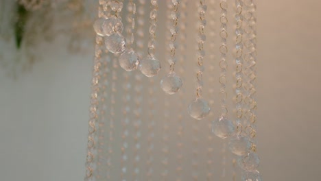 close-up of cascading crystal beads, elegantly hanging in soft lighting, creating a refined and delicate sparkle