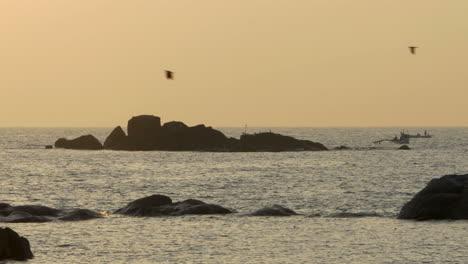 Touristische-Ausflugsboote-Mit-Fischerjungen,-Die-Bei-Sonnenuntergang-In-Der-Silhouette-Auftauchen,-Canacona,-Goa,-Indien