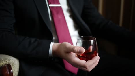 man in a suit holding a glass of wine