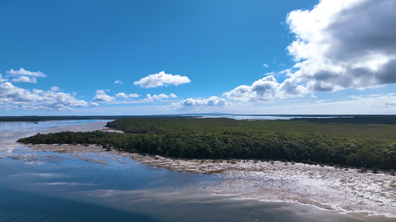 Low flight over dazzling patterned estuary mud flats and forests Queensland