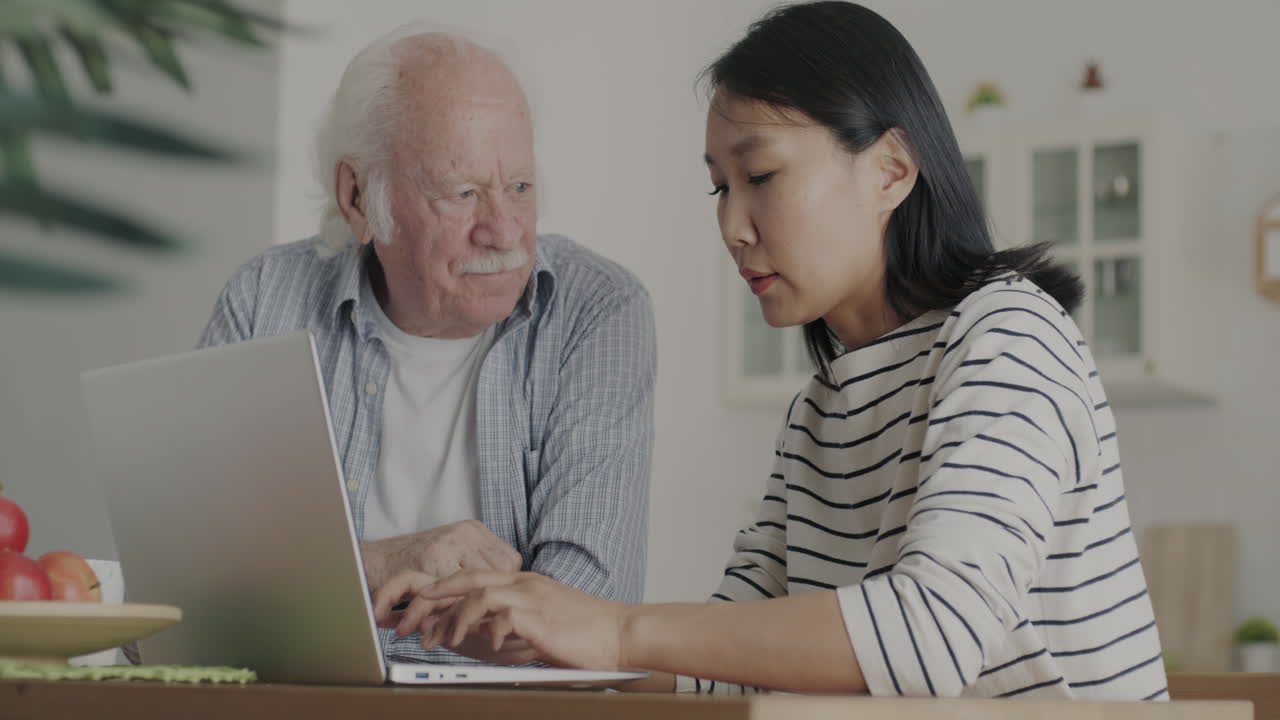 Elderly Man and Woman Learning to Use Laptop Together