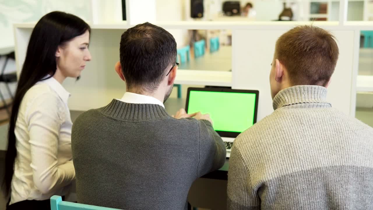 grupo de personas de negocios discutiendo algo en una computadora portátil de pantalla verde