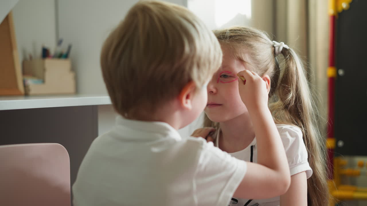남동생 은 여동생 의 얼굴 을  ⁇ 은 연필 으로 칠 한다