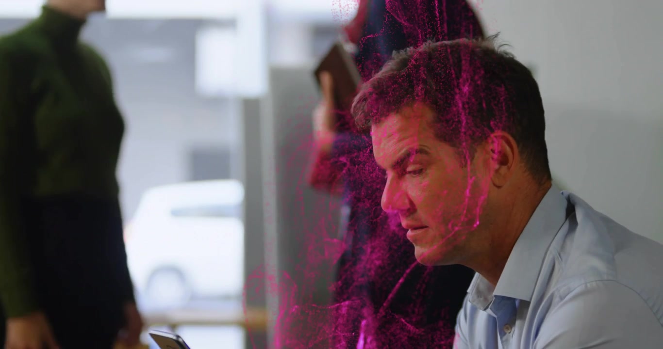 Nuvola magenta che si sovrappone a un uomo che usa il cellulare mentre delle donne si passano un tablet e lavoro di squadra nel business