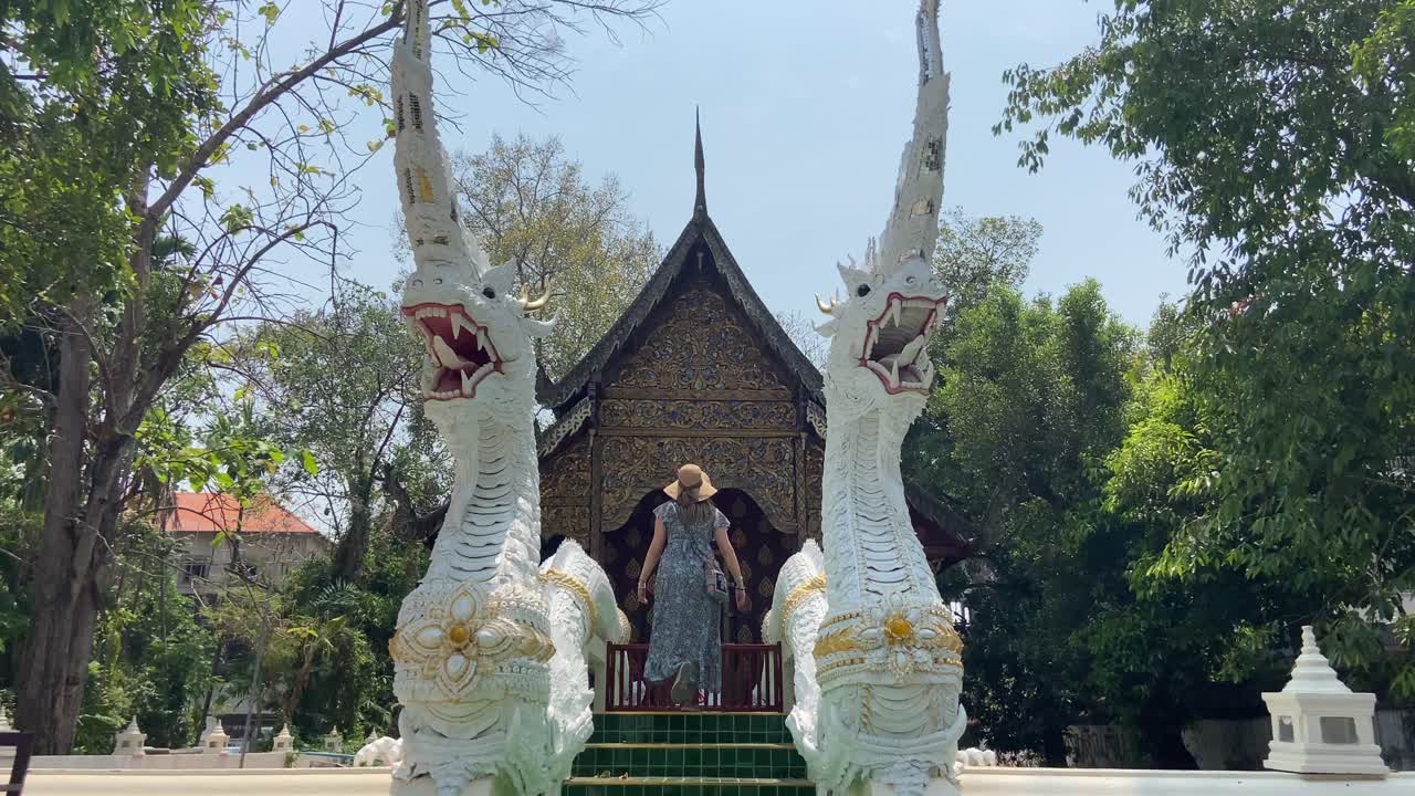 turista mujer con sombrero caminando en el templo tailandés, chiang mai