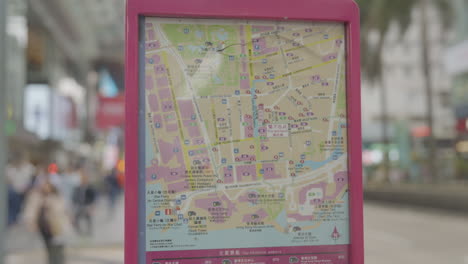 exhibición de mapas de calles de hong kong con telón de fondo de peatones borroso