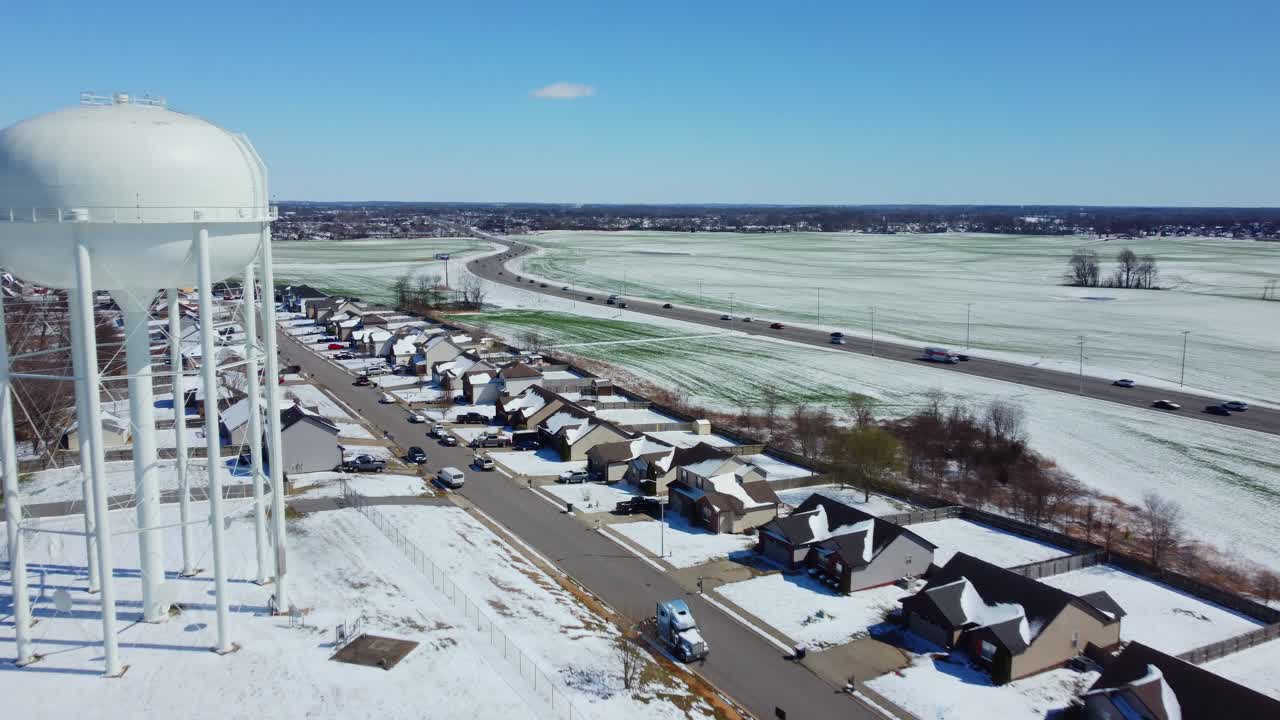 눈이 약간 내리는 교외 지역의 급수탑을 지나 비행