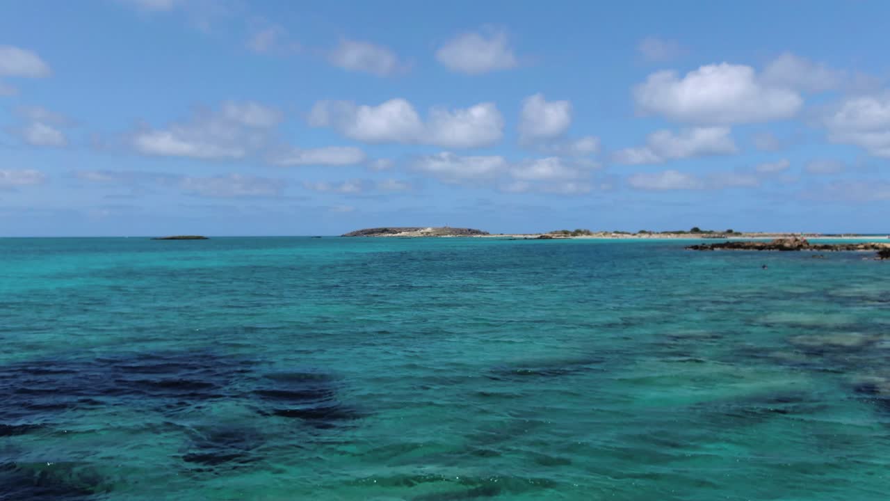 Low fly over idyllic seaside of Crete Island. Amazing turquoise sea