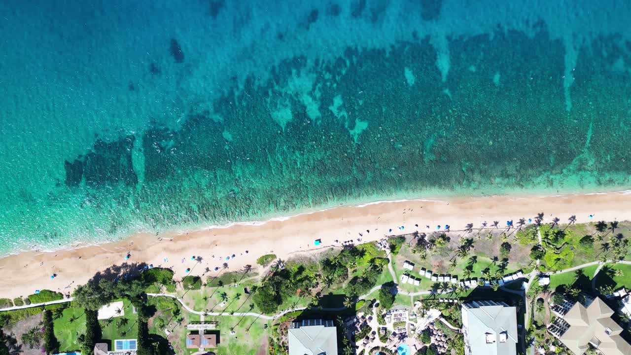 Static overhead drone of Maui’s Airport Beach: shallow water, visible reef, umbrellas