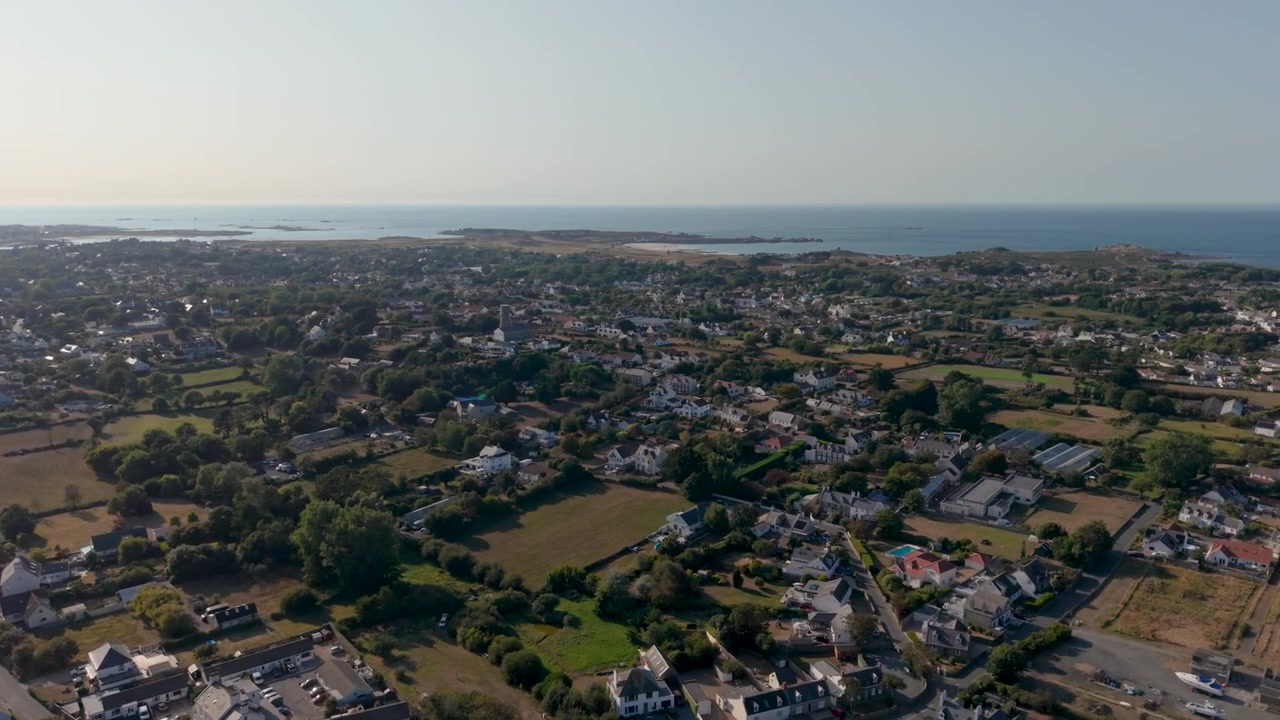 Vale Guernsey. Riprese aeree panoramiche con drone dal bacino idrico sopra i campi e le case della parrocchia di Vale fino a Lancresse Common e alla baia sulla costa settentrionale. Vista dettagliata dell'isola
