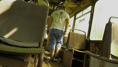 lost person walking through interior of abandoned school bus, static view