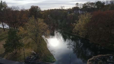 Aerial-View-of-Person-Running-Across-a-Bridge-with-trees-in-background-in-late-evening