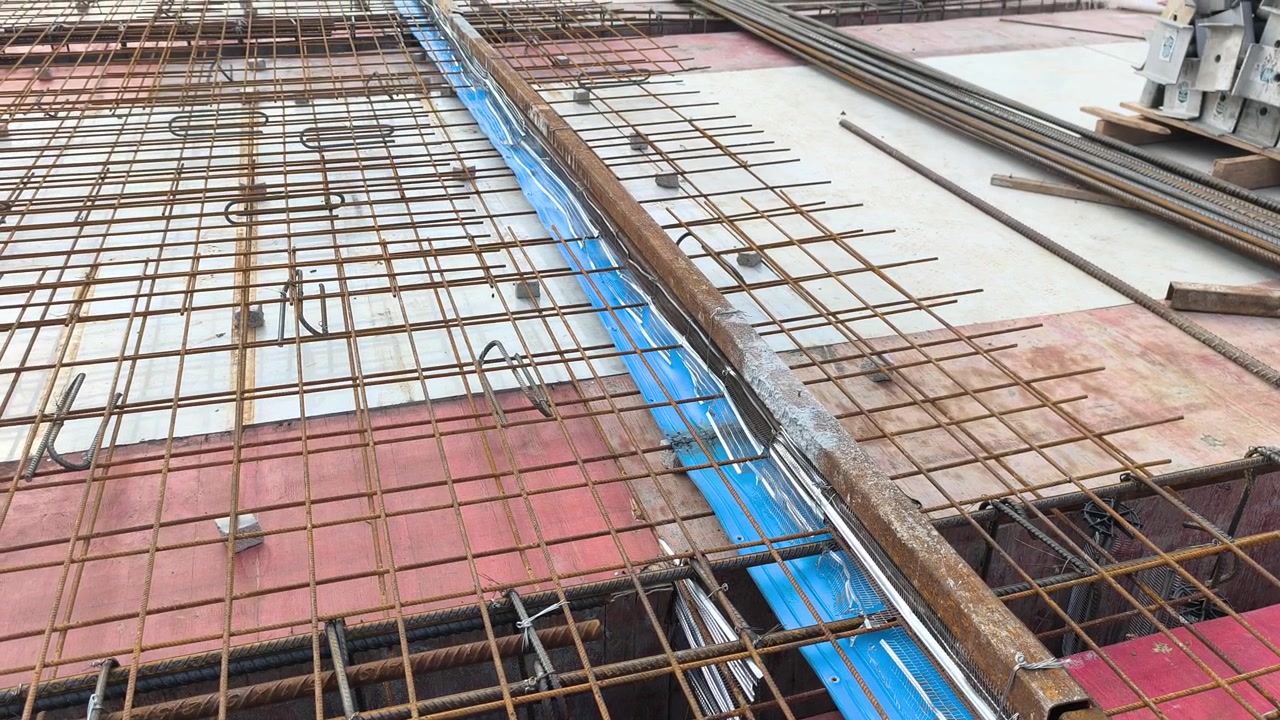 Sebuah Waterstop Karet Biru Dipasang di Sepanjang Sambungan Konstruksi Pelat Beton. Ini Berfungsi sebagai Penghalang untuk Mencegah Masuknya Air Melalui Sambungan Pelat Atap. Pemasangan Ini Memastikan Kedap Air Struktural
