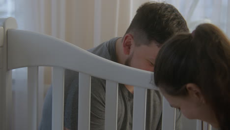 couple looking at each other and assembling crib close up view couple looking at each other and assembling crib for newborn baby at nursery loving parents together preparing room for adorable infant concept of parenthood childhood and family