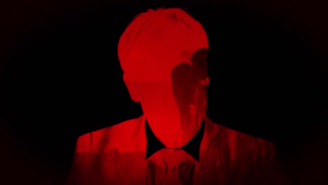 hombre con luz roja y dos siluetas besándose sobre un fondo negro