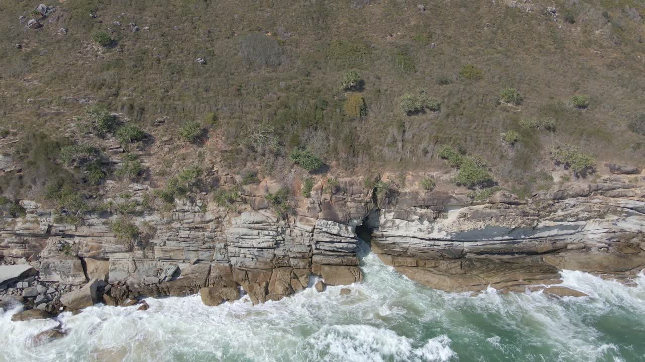 olas oceánicas rompiendo en la costa rocosa de half tide beach en nueva gales del sur, australia