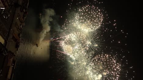 Flyover vertical view of a ship launching coordinated fireworks on New Year&#039;s Eve 2023 in Valparaiso Chile